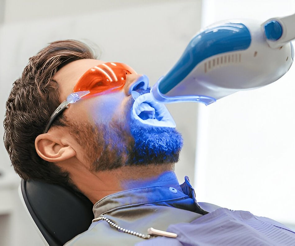Man receiving professional teeth whitening with blue LED light