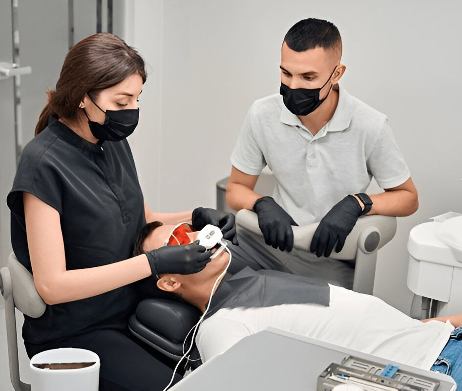 Dental professionals performing a teeth whitening procedure on a patient